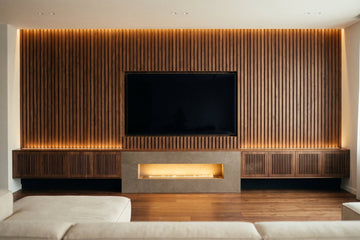 Walnut slat media wall with a recessed TV, floating console and linear fireplace in stone