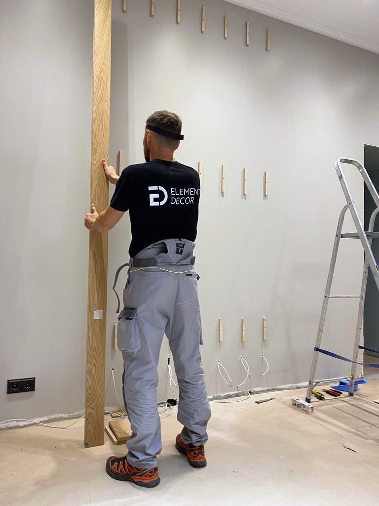 Andrew, founder of Element Decor, setting a white oak slat on a wall