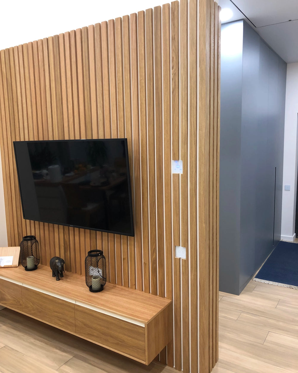 Slat wall built around a television by Element Decor